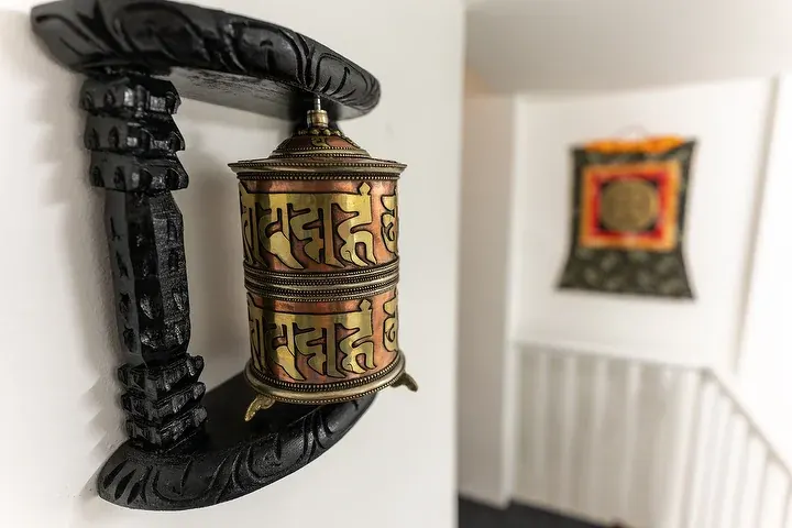 A carved prayer wheel mounted on the wall